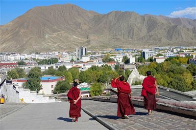 Drei junge buddhistische Mönche gehen die Straße entlang
